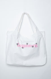 White canvas tote bag with pink 'Beginning' text and small grey koala illustrations