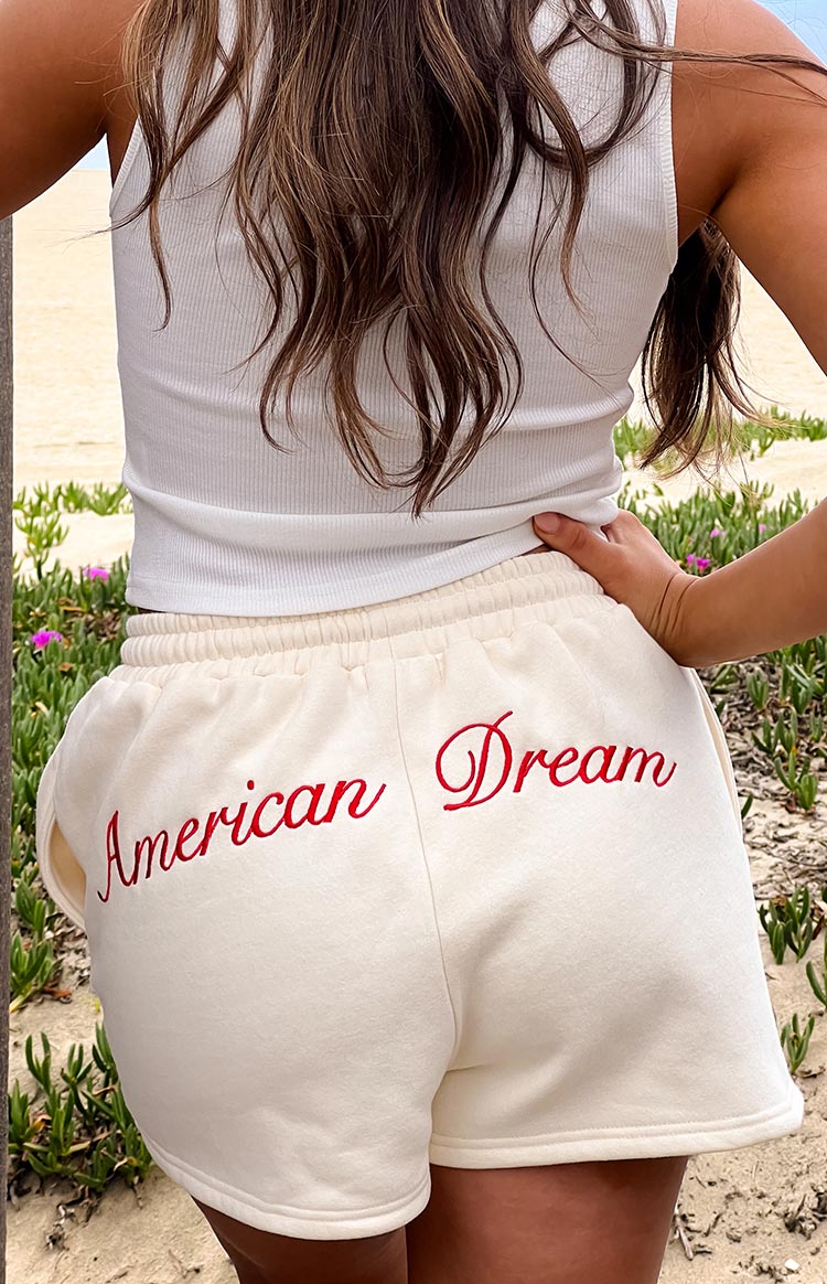 Rear view of cream lounge shorts with red embroidered 'American Dream' text across the back