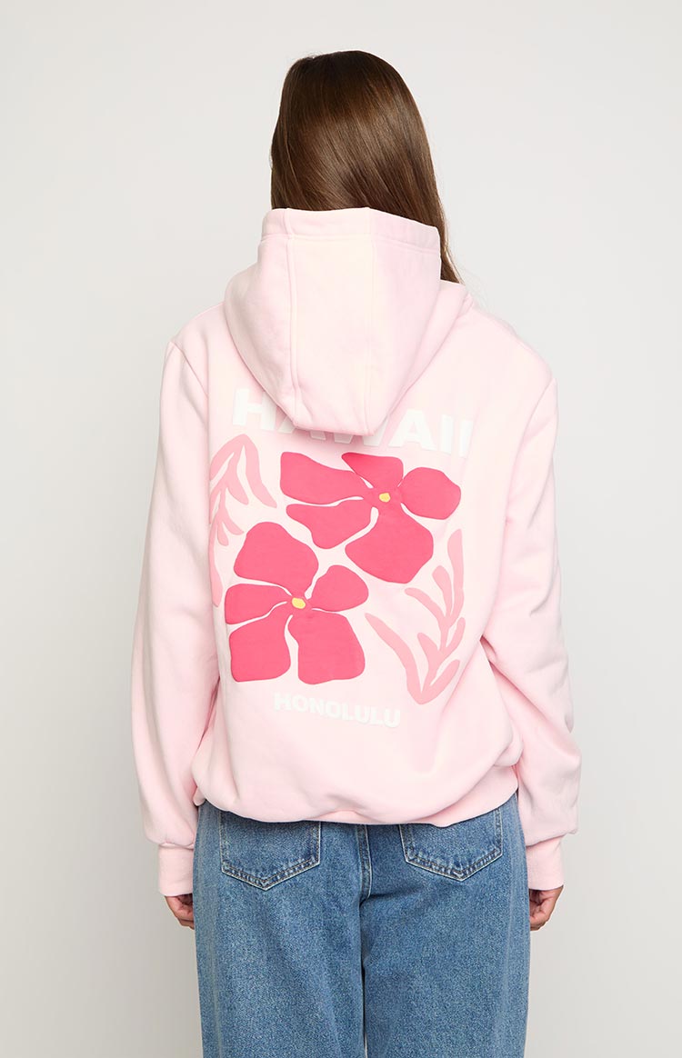 Rear view of a light pink hoodie with a large pink hibiscus floral print and "HAWAII HONOLULU" text on the back