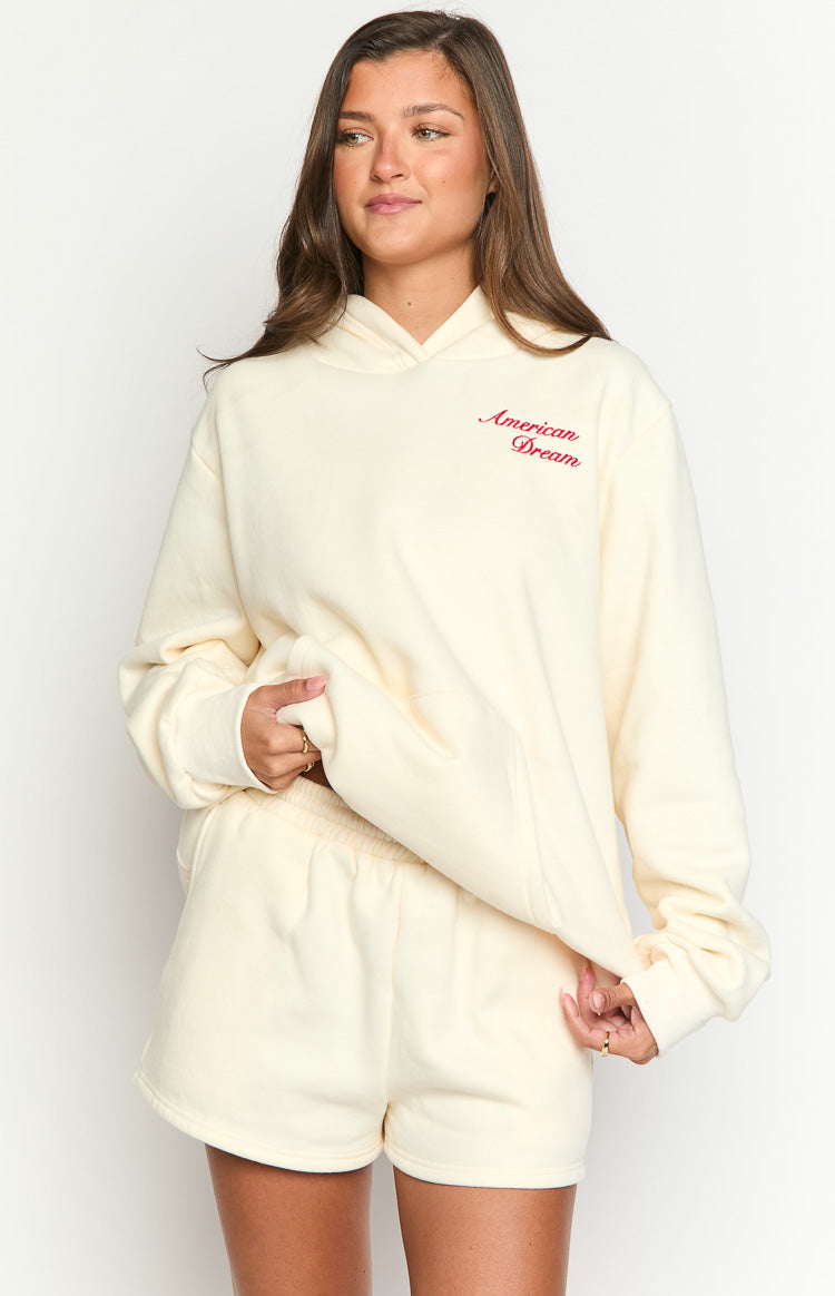 Cream oversized hoodie with red American Dream script embroidery on the chest and a front kangaroo pocket