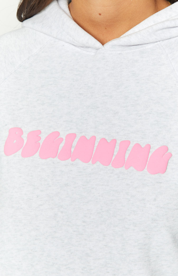 Close-up of the pink bubble font BEGINNING text graphic on a grey marl hoodie