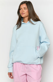 Light blue oversized hoodie with a front kangaroo pocket and a pink gingham star detail peeking out