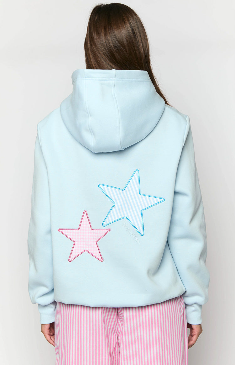 Rear view of a light blue hoodie with a pink gingham star and a blue striped star applique on the back