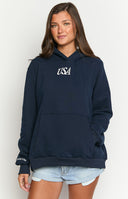 Girl wearing a navy sweatshirt with a red and blue embroidered flag on the back- paired with red and white striped shorts