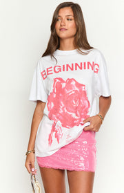 Front view of an oversized white tee with a large pink rose graphic and 'BEGINNING' text