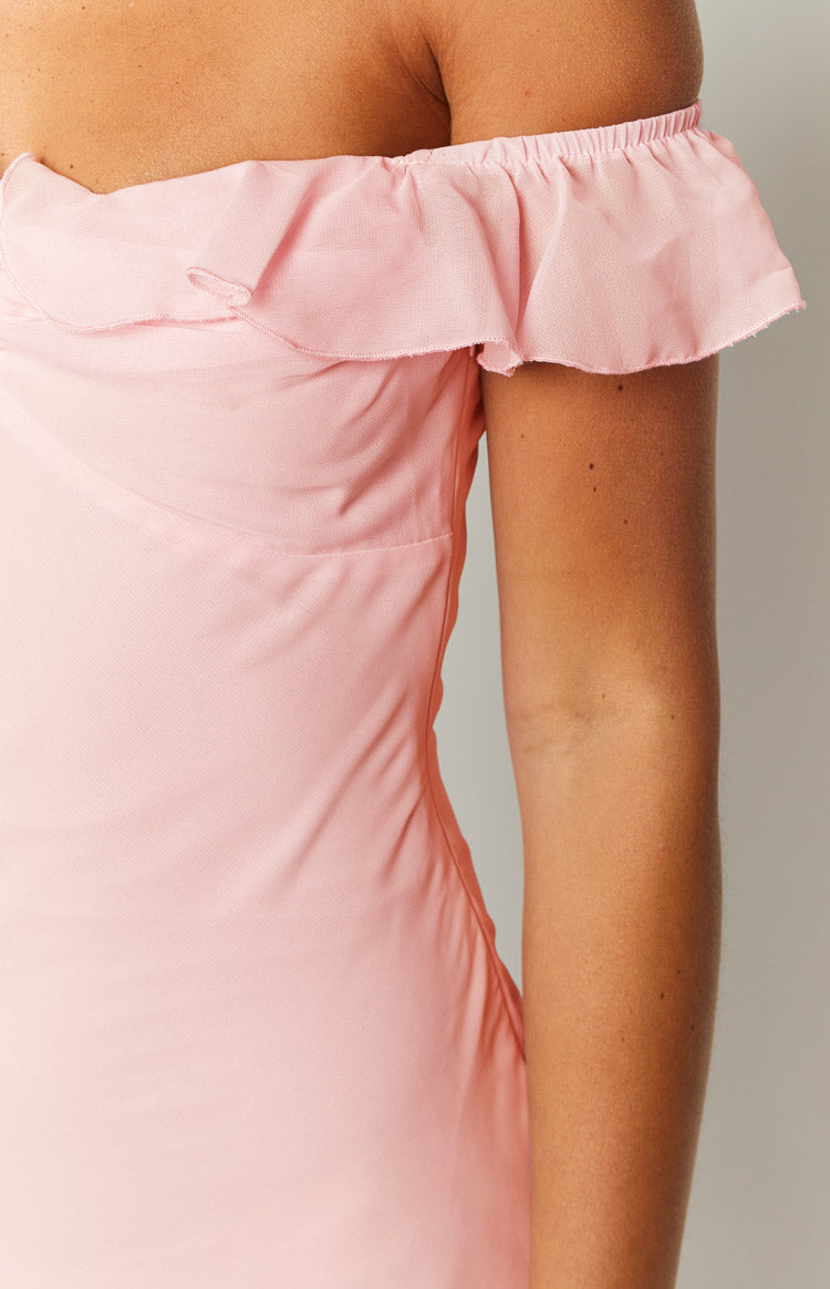 Close-up of the off-shoulder neckline with elasticated ruffle trim on a pink chiffon maxi dress