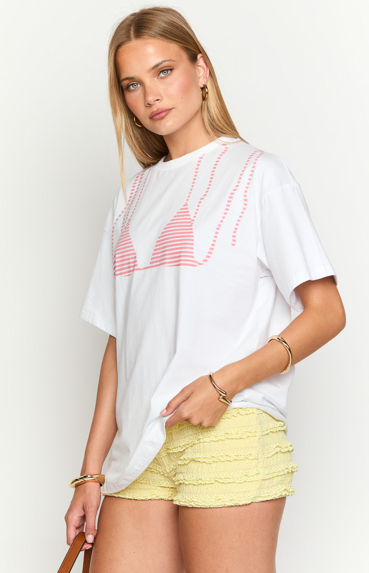 White oversized tee with a pink striped bikini top graphic and dotted pink lines above it