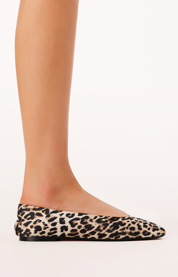 Side view of a leopard print ballet flat with a pointed toe and flat black sole