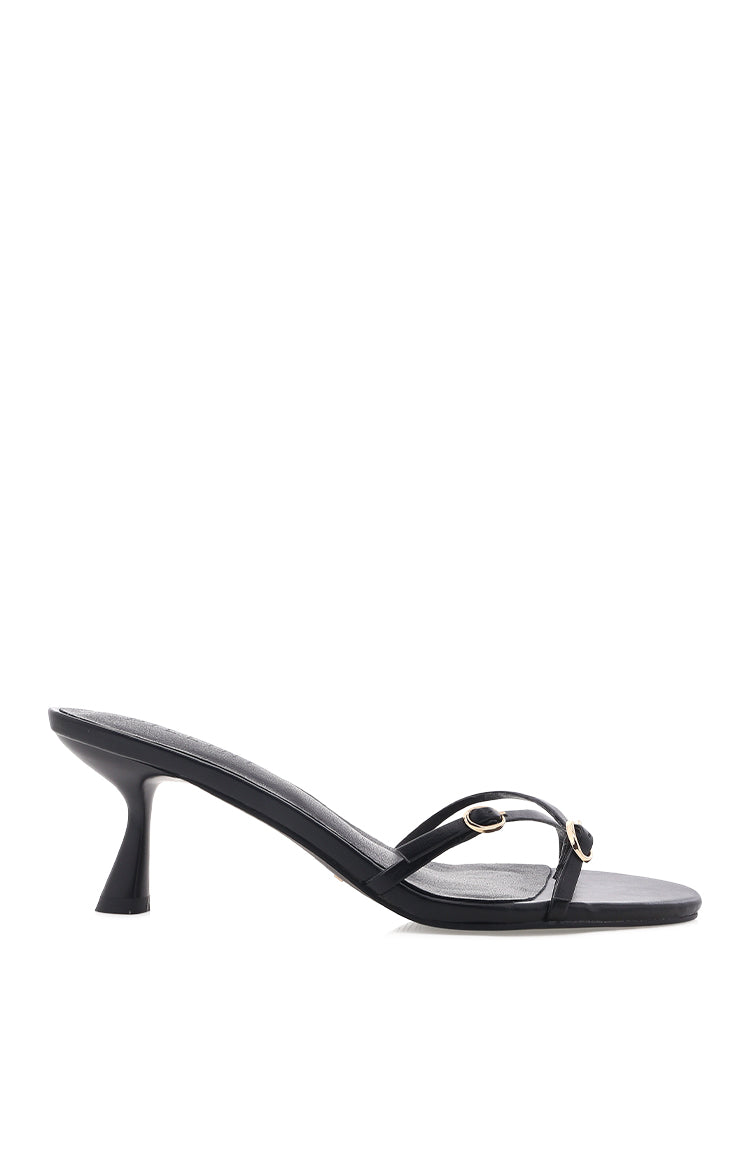 Side view of black heels with a kitten heel and two thin straps with gold buckles