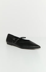 Black ballet flat with a pointed toe and a thin strap tied in a bow across the instep