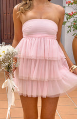 Close-up of a pink strapless mini dress featuring a ruched bandeau bodice and layered tiered tulle skirt