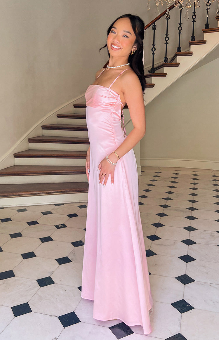 Side view of a pink satin maxi dress showing the ruched bust and delicate side lacing detail