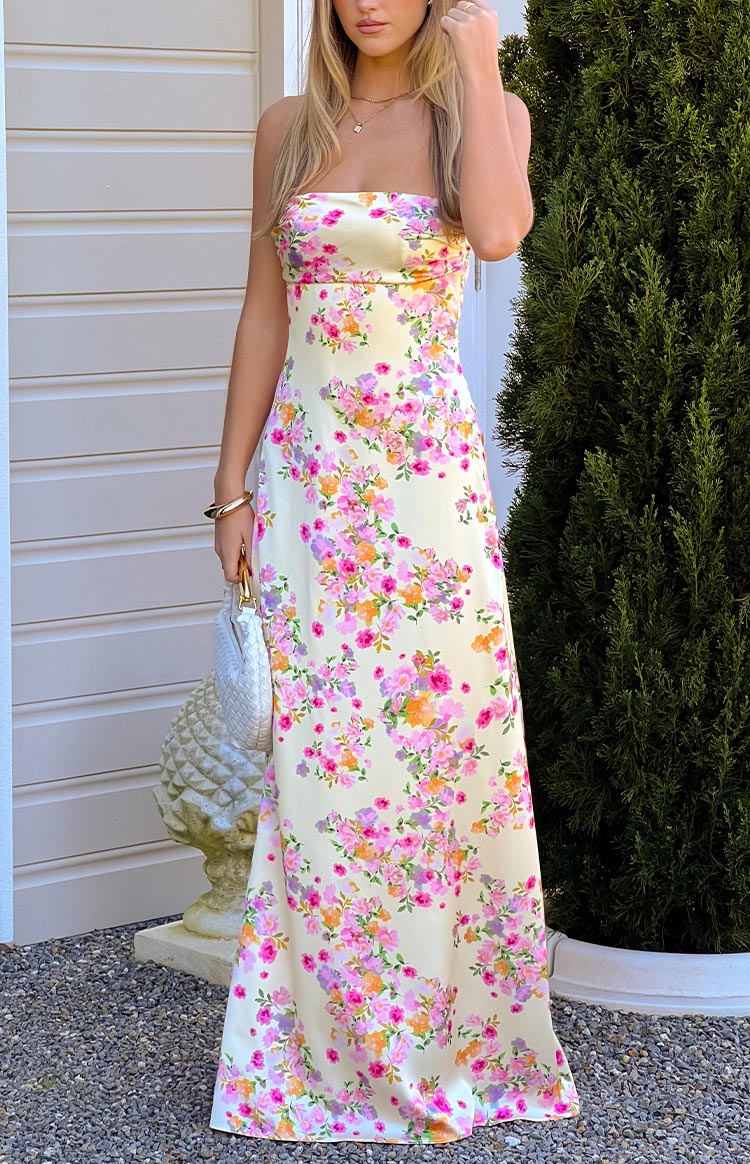 A beautiful pale yellow satin maxi dress adorned with pink and orange floral blooms- designed in a sleek silhouette- perfect for a summer formal or garden party.