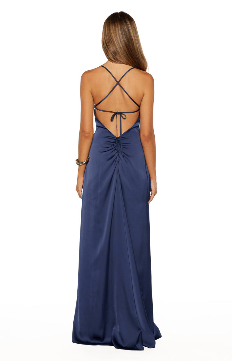 Back view of the navy satin maxi dress showing criss-cross straps, low scoop back, and ruched tie detail