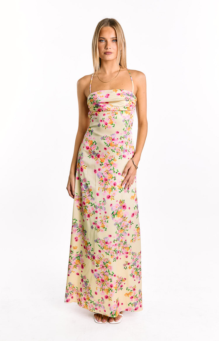 Front view of a yellow satin maxi dress with a vibrant pink, orange, and purple floral print