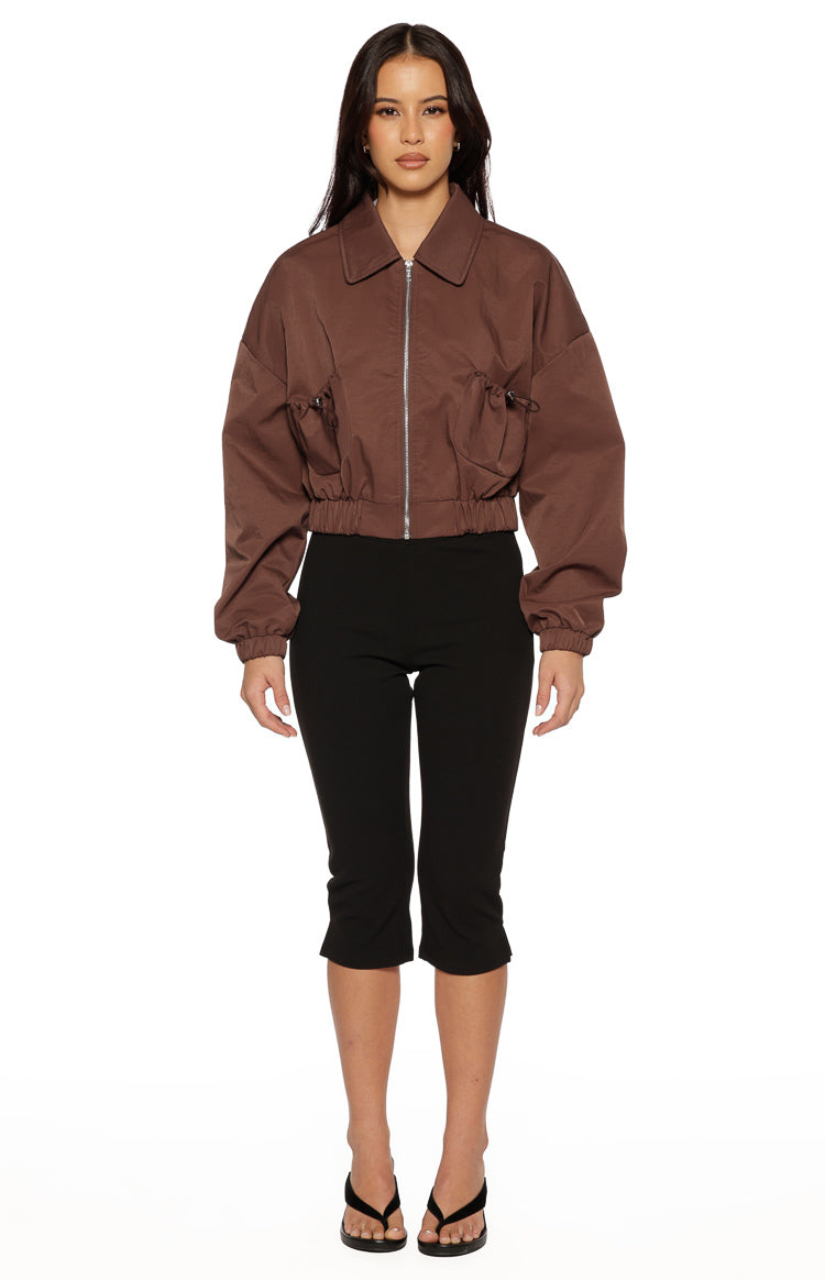 Front view of a chocolate cropped bomber jacket with a collar, zip, and gathered drawstring details