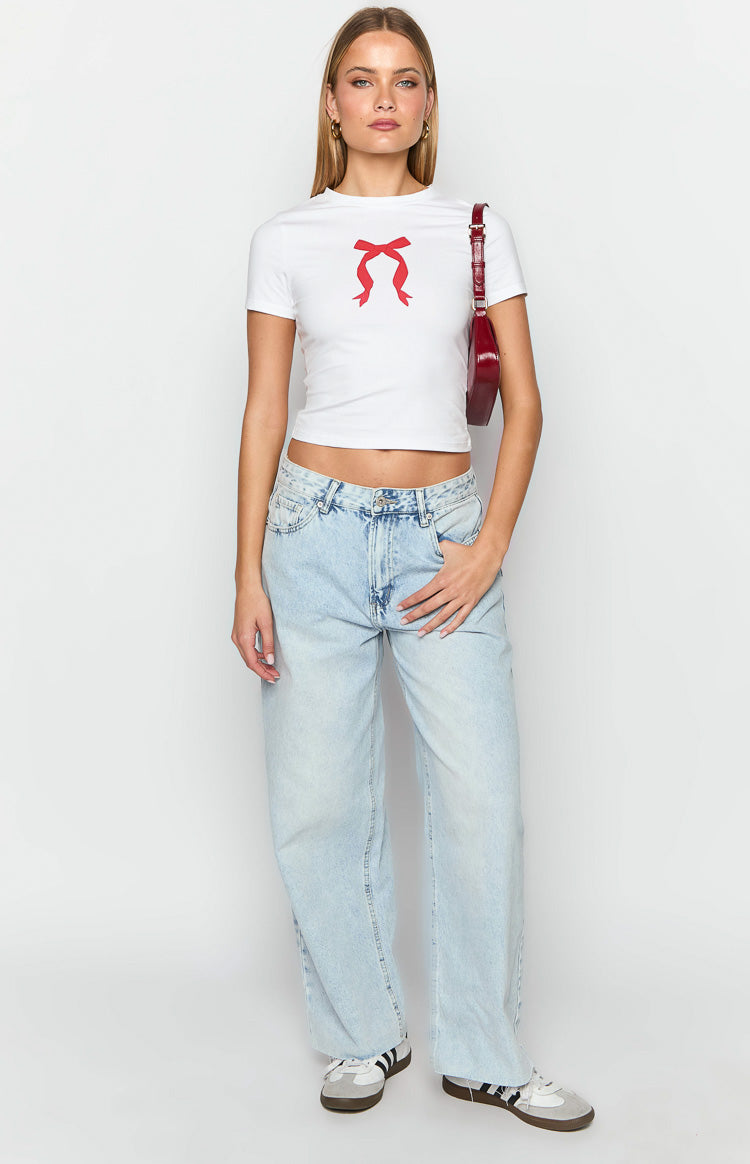 White fitted baby tee with a red bow graphic and short sleeves, showing cropped length