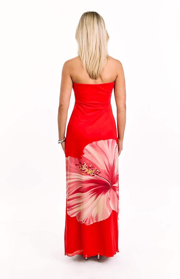 Rear view of a red strapless maxi dress with a large pink hibiscus print on the lower right side