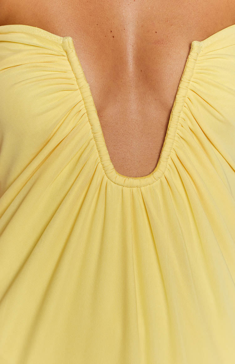 Close-up of the yellow strapless dress with a ruched deep V-neckline