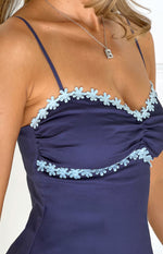 Close-up of the navy mini dress bodice with light blue flower trim and ruched bust