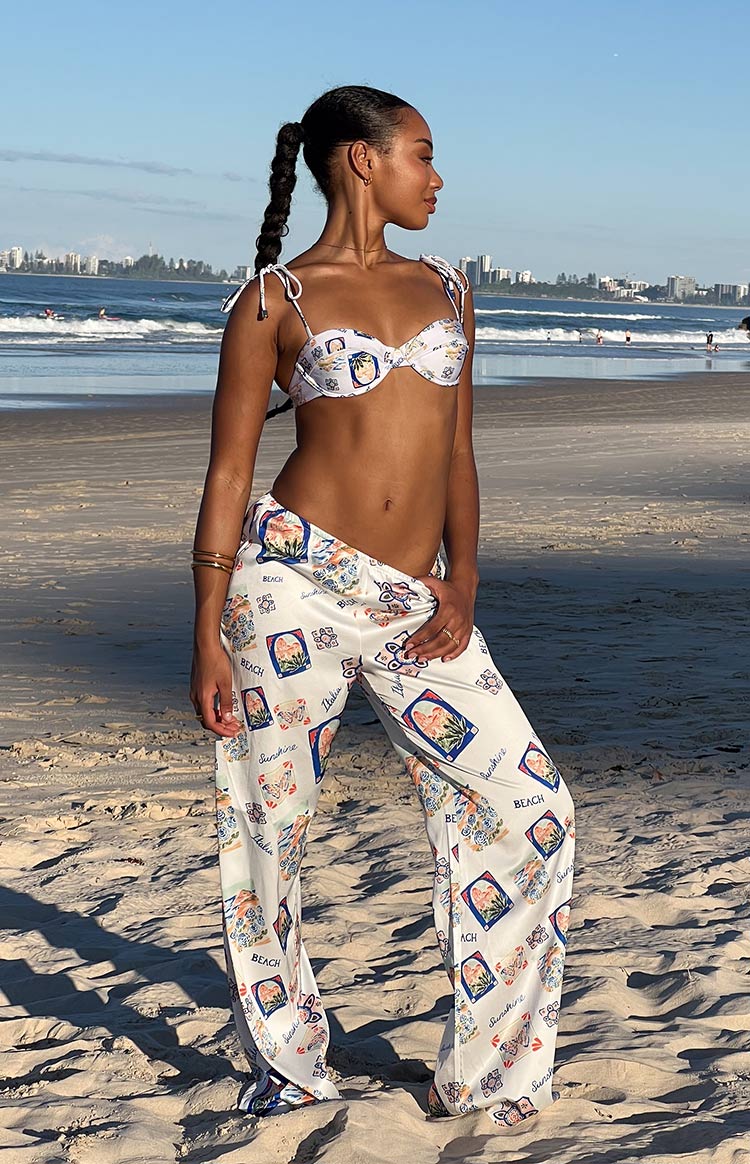 Side view of white satin wide-leg pants with a colourful Italia print, showing the flowy fit