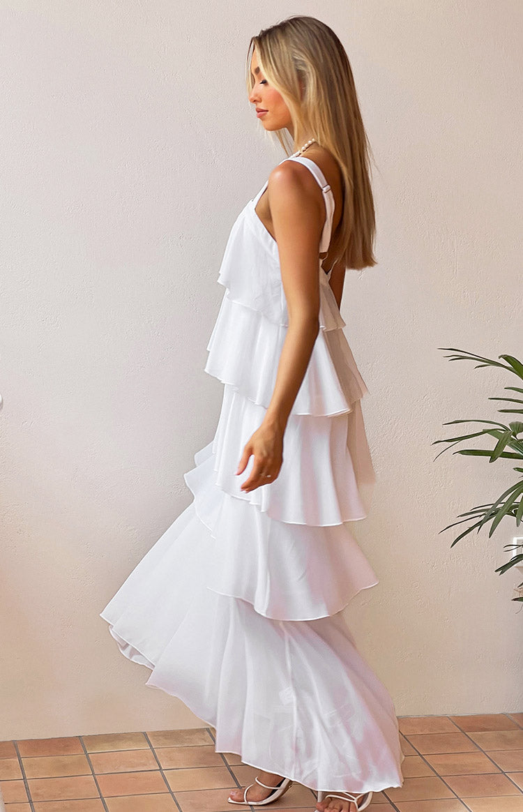 Side view of a white layered frill maxi dress showing the tiered ruffles and flowy skirt