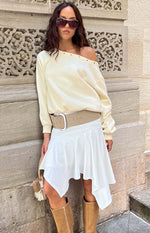 Front view of the white asymmetrical midi skirt with a flowy drape and pointed hem