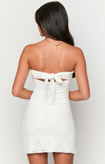 Rear view of a white lace mini dress showing the tie-back detail and ruched bodice