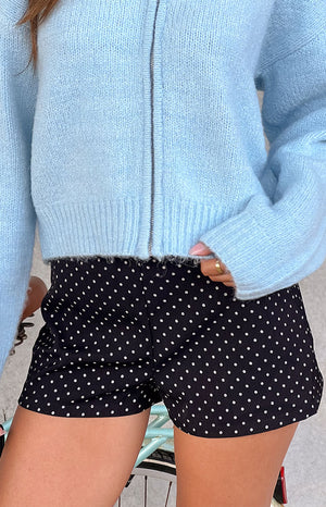 Our model wearing a pair of black high-waisted shorts with a small white polka dot pattern.