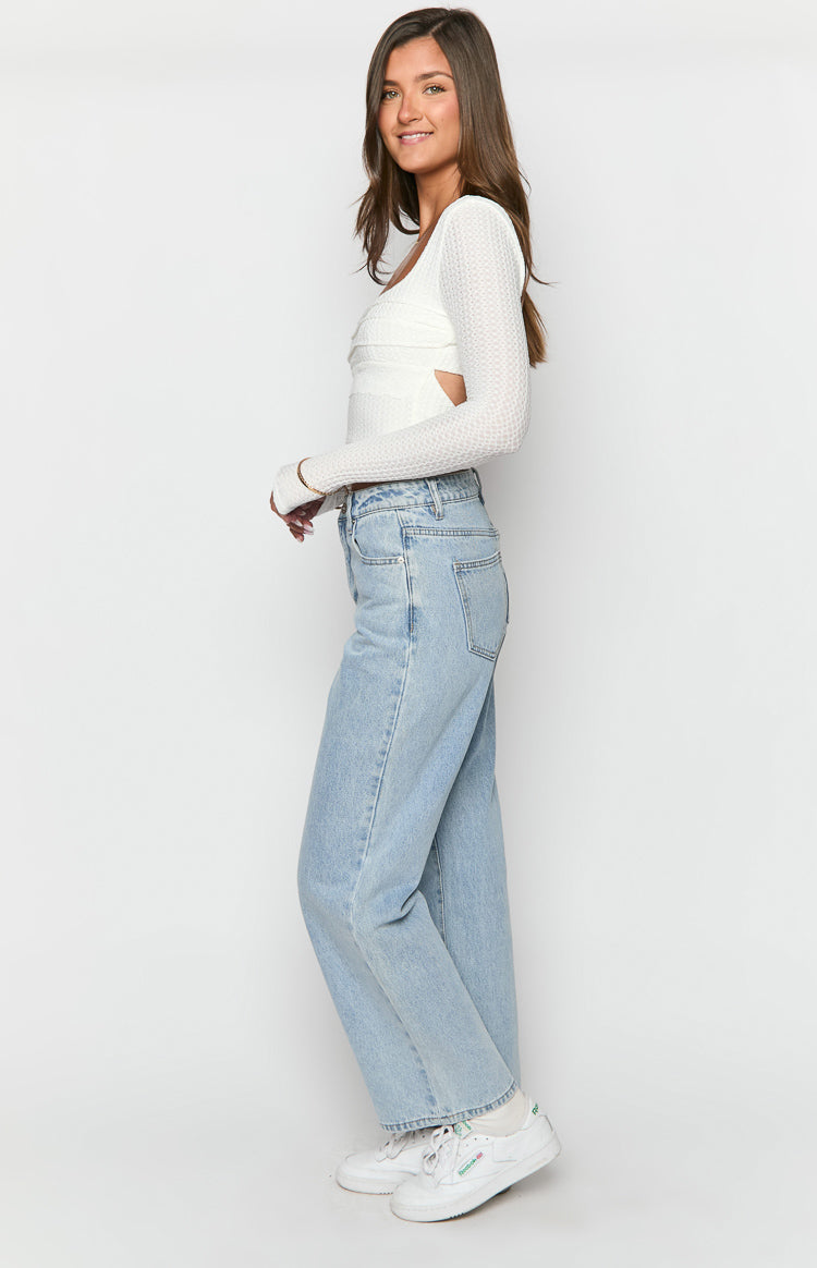 Side view of light wash mid-rise slouchy jeans with a relaxed straight leg fit