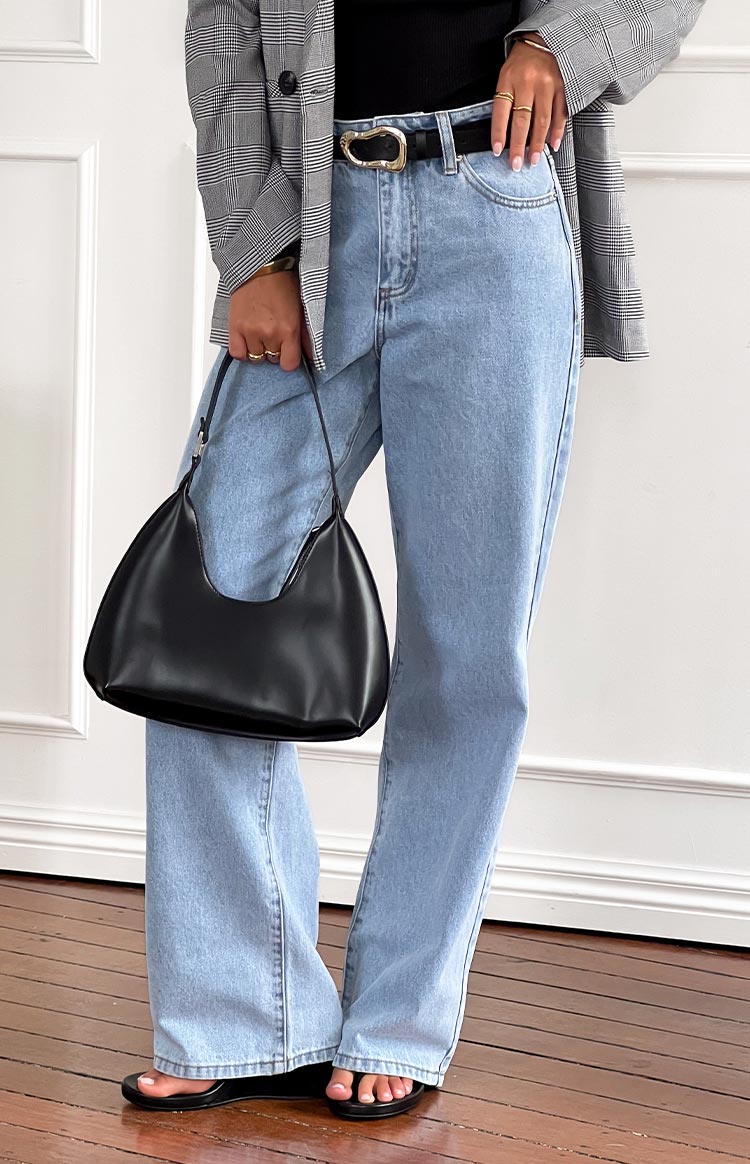 Light wash mid-rise slouchy jeans with a wide-leg fit and full length, showing the hem resting on the floor