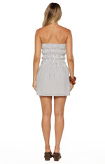 Rear view of a blue and white vertical stripe strapless mini dress with a shirred bodice and elasticated waist