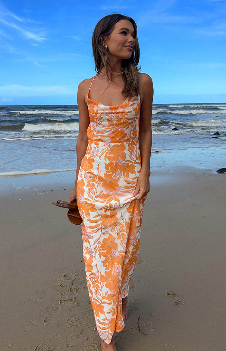 Flowy white chiffon maxi dress with orange and pink floral print, a draped cowl neck, and thin spaghetti straps