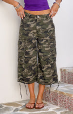 Green camo cargo shorts with large side pockets and adjustable drawstring ties at the knee-length hem