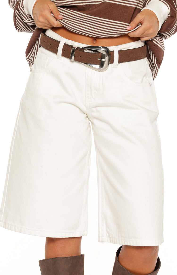 Close-up of the dark brown suedette belt with a curved silver buckle and single prong