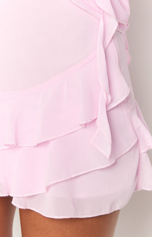 Close-up of the pink chiffon mini skirt showing the layered ruffles and side tie detail