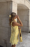 Front view of a yellow chiffon mini skirt with cascading tiered ruffles and a flowy hem