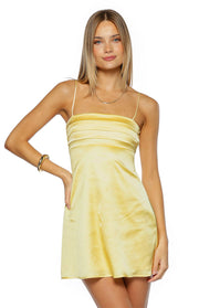 Front view of a yellow satin mini dress with a square neckline and pleated bodice