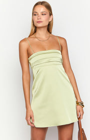 Bodice detail of a sage green satin mini dress with a square neckline, thin straps, and horizontal pleating