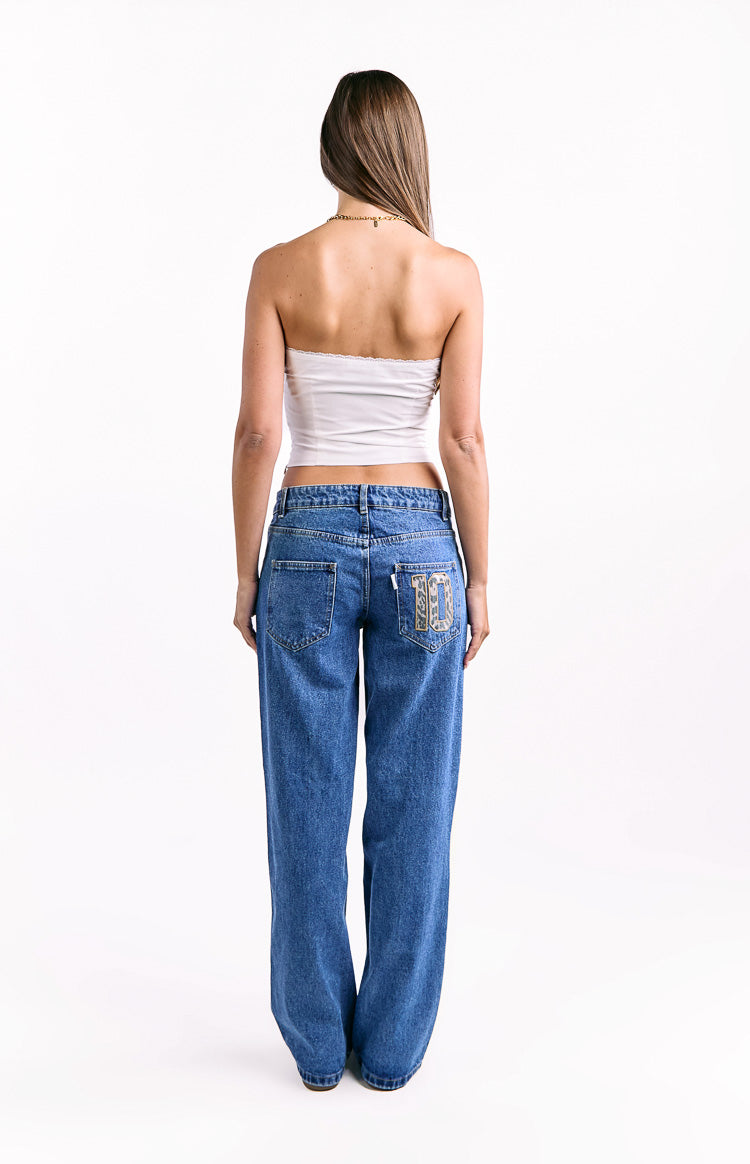 Back view of mid-wash blue low waist baggy jeans showing the patterned '10' patch on the right pocket