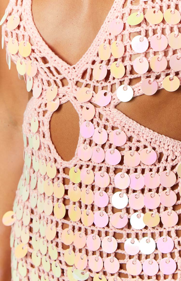 Close-up of the pink crochet knit, iridescent sequins, and a side cutout detail on the mini dress