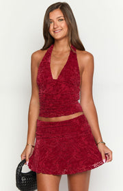 Front view of a red velvet mini skirt with a textured pattern and ruched waistband