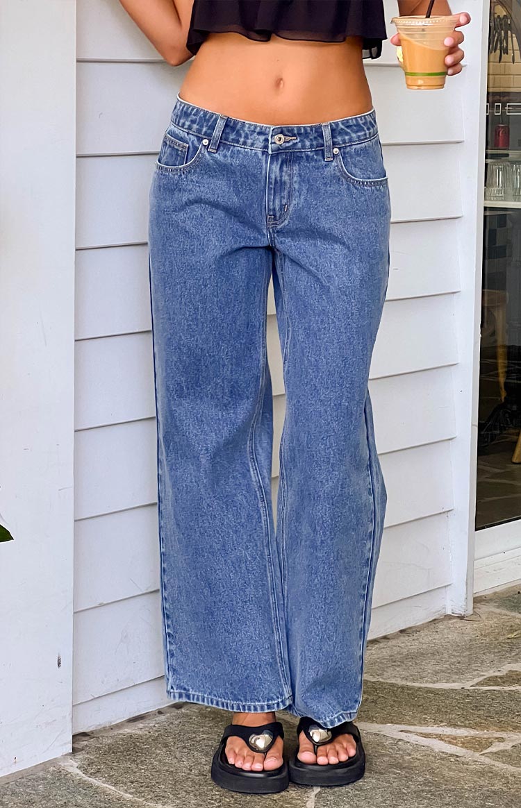 Front view of mid wash denim low rise jeans with a relaxed wide leg and subtle whiskering