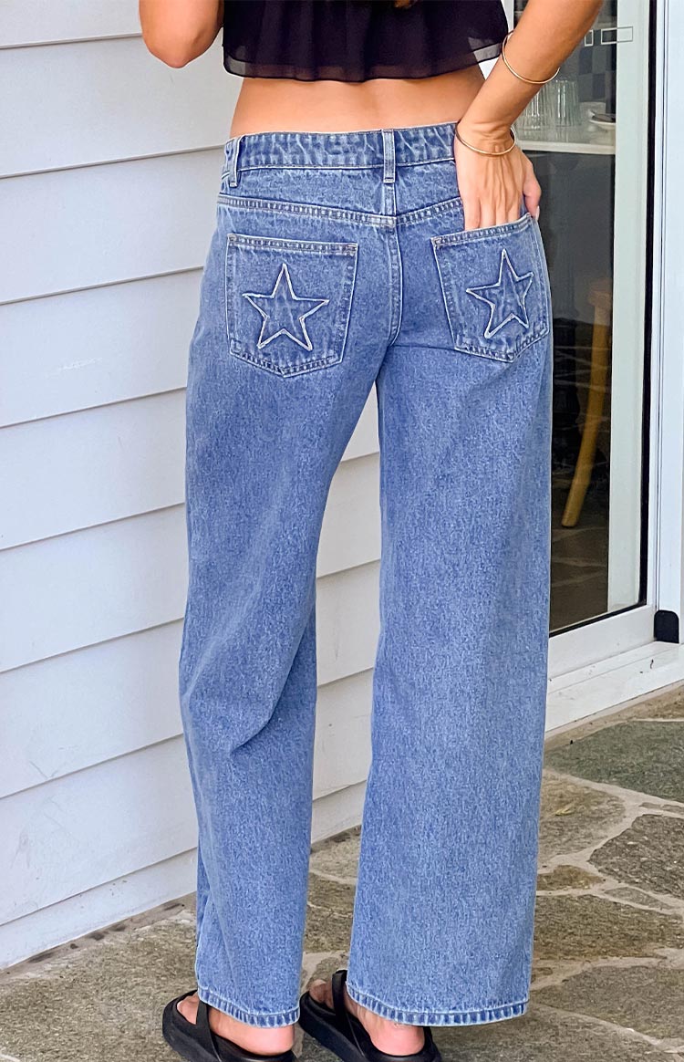 Beginning Boutique Clara Star Mid Wash Denim Low Rise Jeans mid wash denim low rise jeans with white star embroidery on back pockets and a straight leg fit