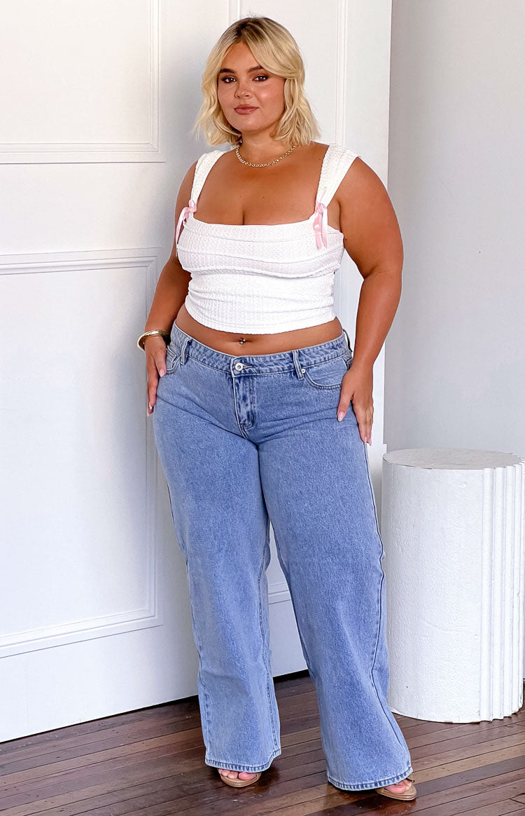Mid wash light blue low rise jeans with a relaxed wide leg silhouette and full length hem
