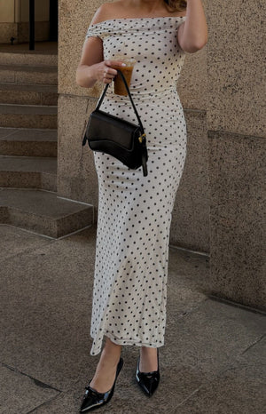 Fitted white mesh maxi dress with black polka dots and an off-shoulder neckline