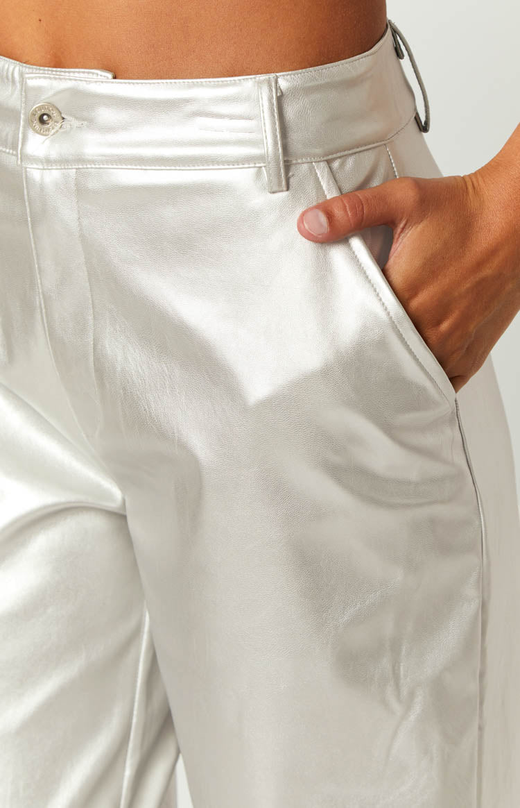 Close-up of the metallic silver pants showing the side pocket, waistband, and button closure