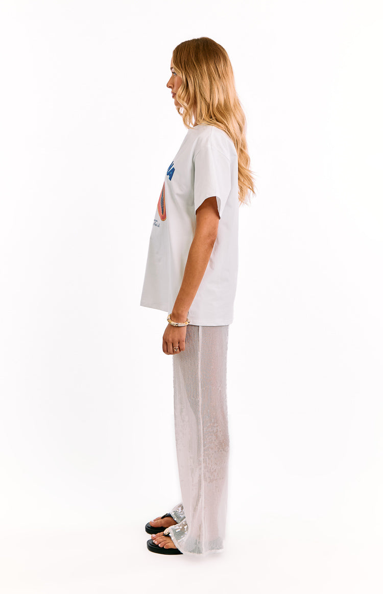Side view of white sequin wide leg pants, showing the sheer fabric and relaxed, full-length cut