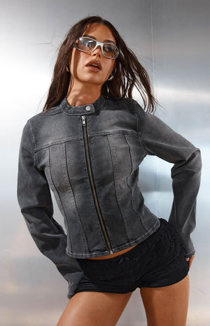 Model in a black washed denim biker jacket styled with black shorts a cool top layer for a Spring Festival
