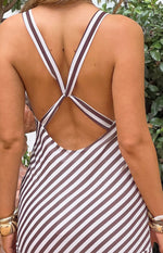 Rear view of a brown and white diagonal stripe maxi dress with criss-cross back straps and a low scoop back
